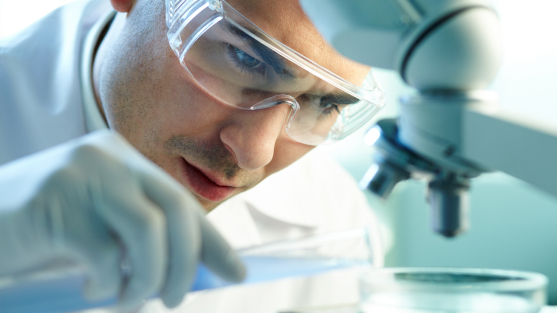 pharmacist looking at specimen under microscope