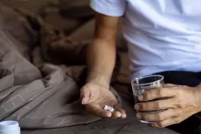 man taking pill in bed